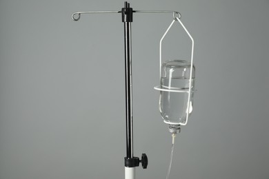 Photo of IV infusion set on pole against grey background