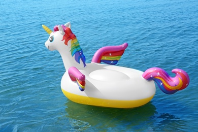 Photo of Funny inflatable unicorn ring floating on sea water. Summer vacation