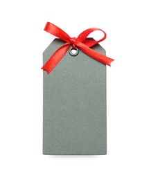 Photo of Blank grey gift tag with red satin ribbon on white background, top view. Space for design