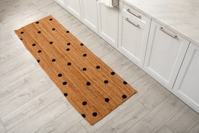 Stylish rug with dots on floor in kitchen
