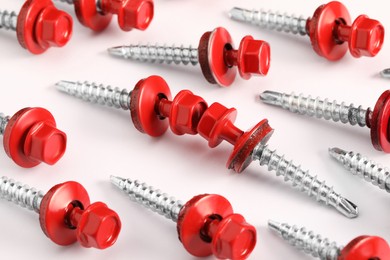 Red self-tapping screws on white background, closeup