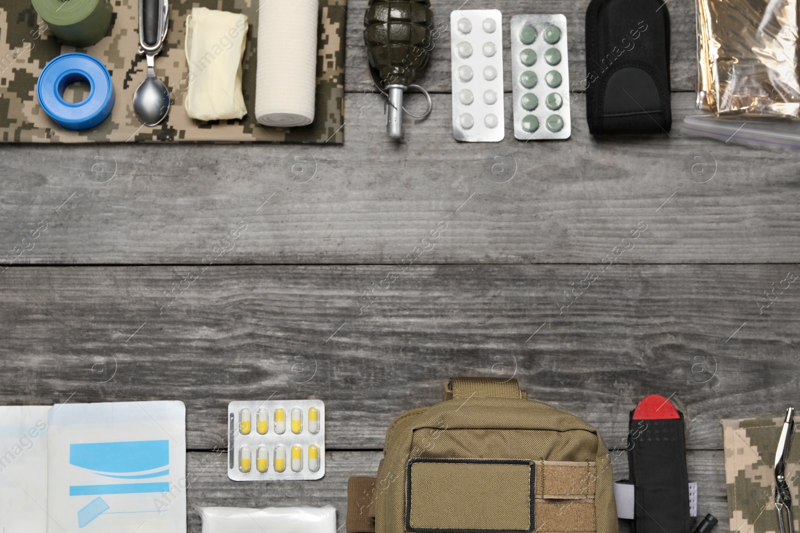 Photo of Flat lay composition with military first aid kit on wooden table. Space for text