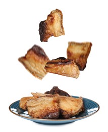 Image of Tasty fried pork lard falling into plate on white background 