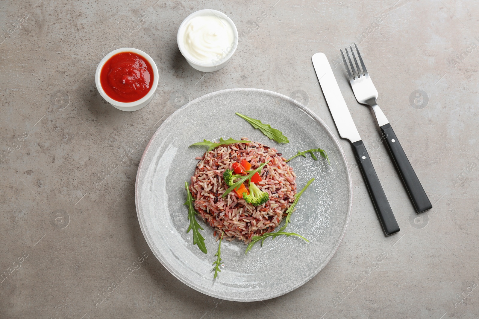 Photo of Delicious brown rice served on light table, flat lay