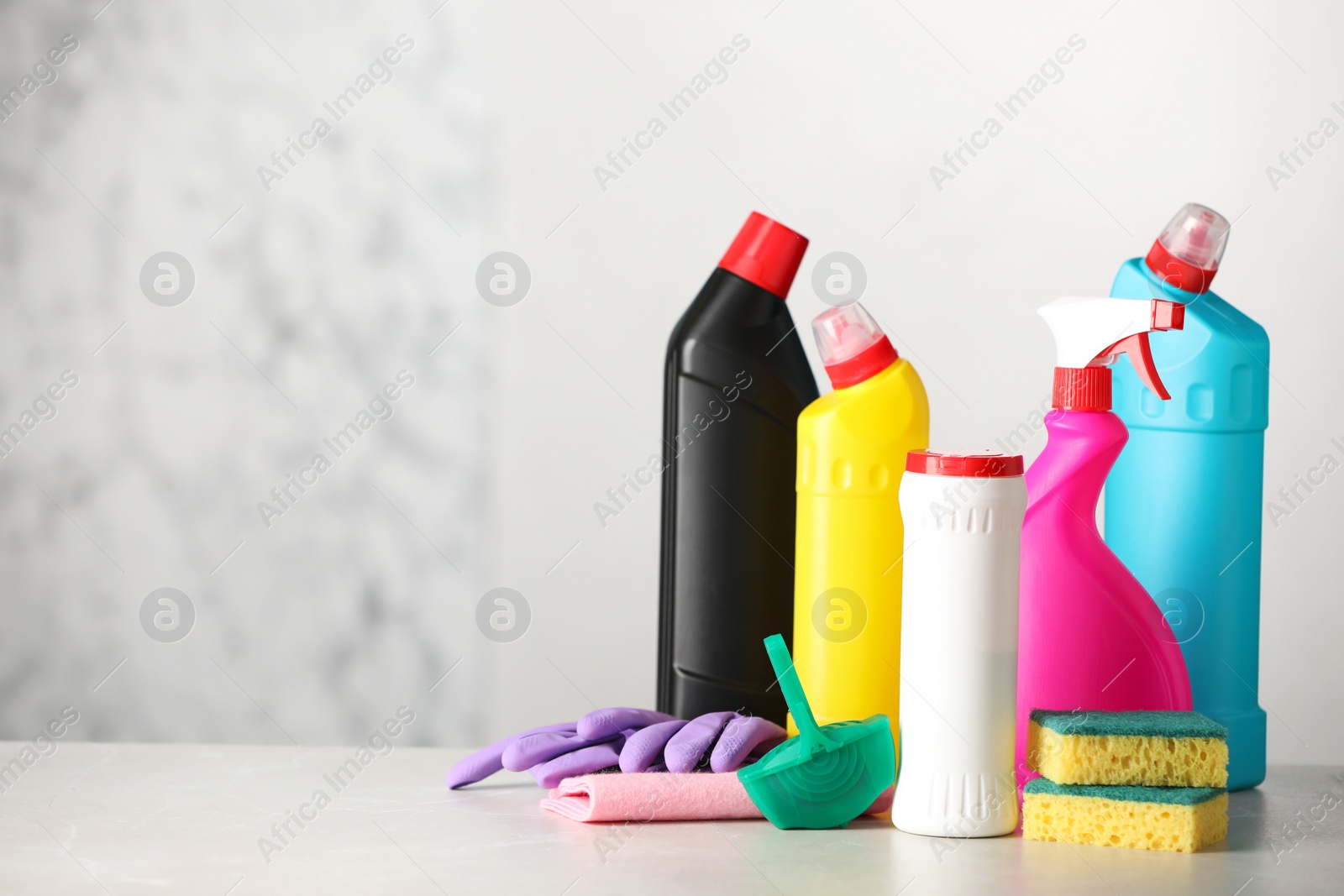 Photo of Different toilet cleaning supplies and tools on light grey table, space for text