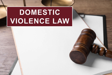 Image of Clipboard and gavel on wooden table. Domestic violence law concept