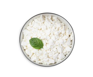 Fresh cottage cheese with basil in bowl isolated on white, top view