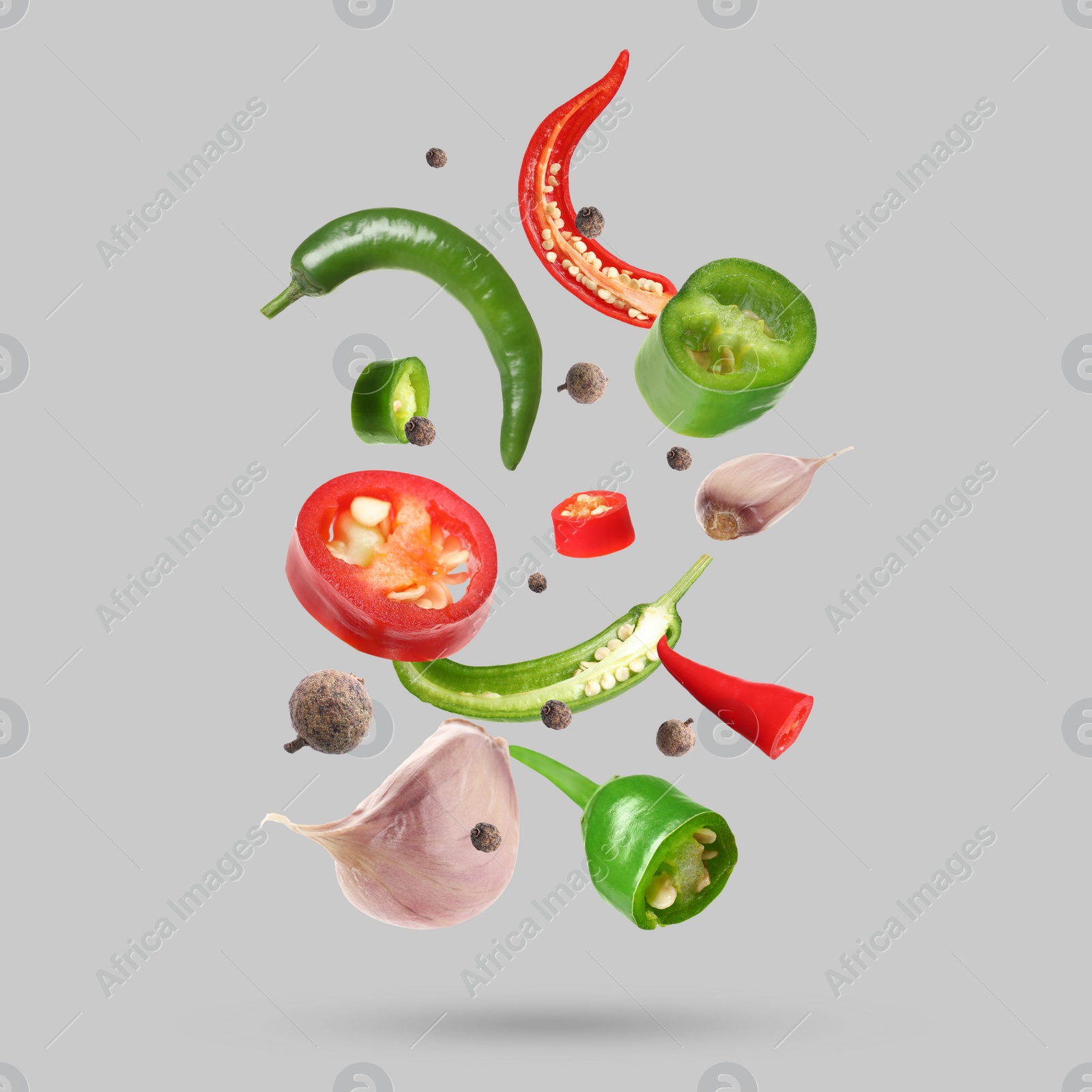 Image of Different spices falling on light grey background