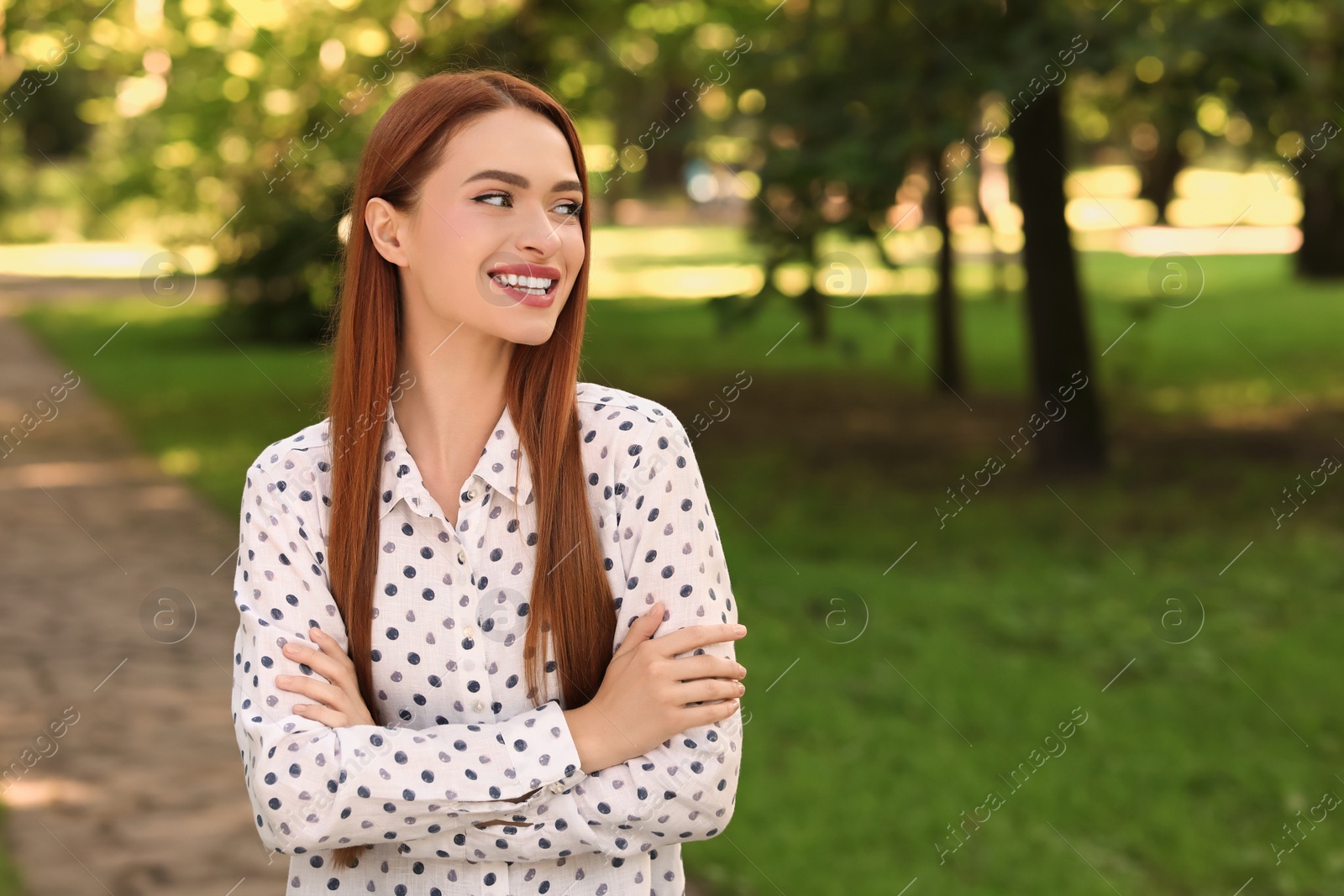 Photo of Portrait of happy young woman outdoors. Space for text. Attractive lady smiling and posing for camera