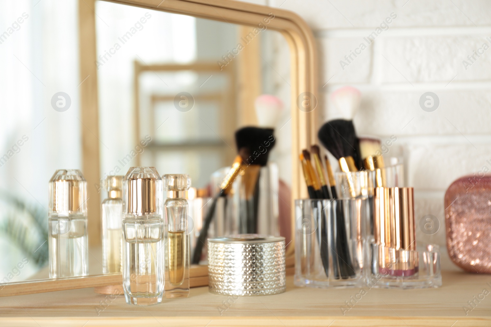 Photo of Perfumes and makeup products on dressing table