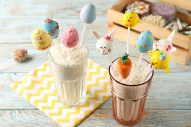 Delicious sweet cake pops for Easter celebration on light wooden table