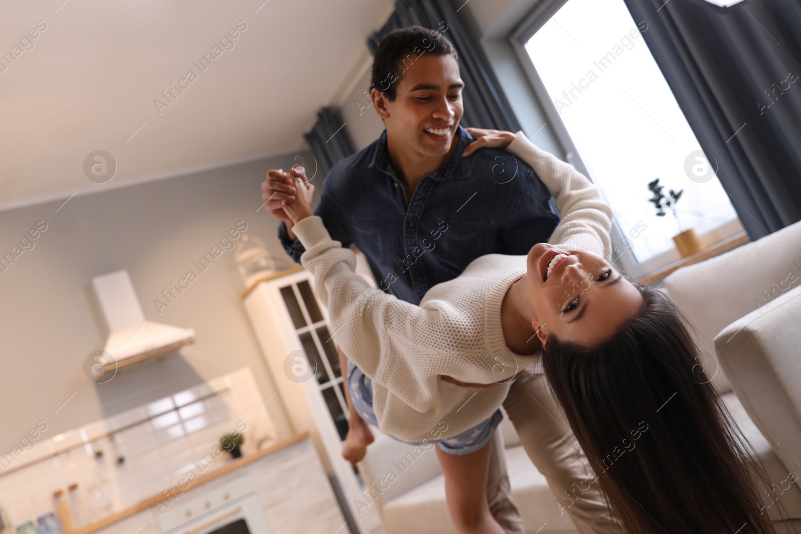 Photo of Lovely young interracial couple dancing at home