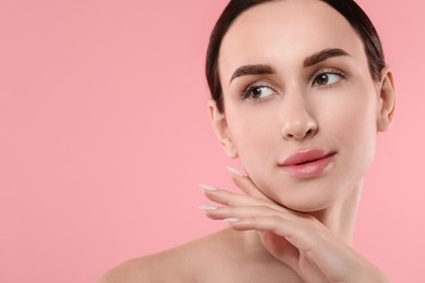 Photo of Portrait of beautiful young woman on pink background. Space for text