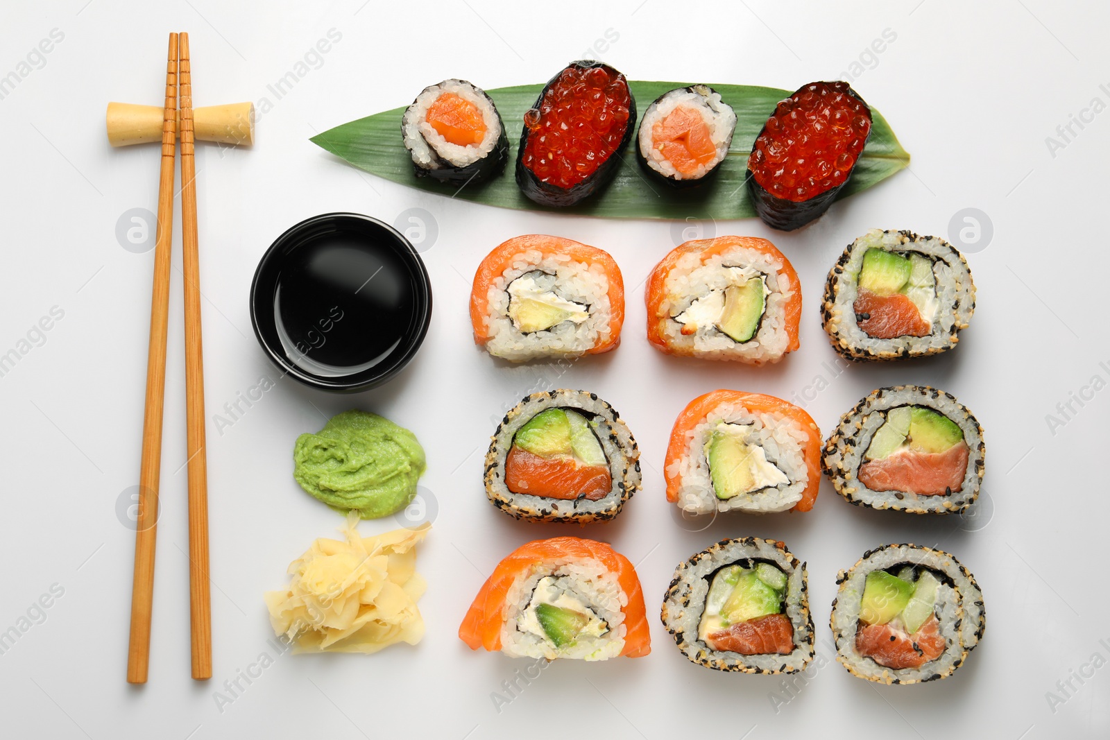 Photo of Set of delicious sushi rolls on white background, flat lay