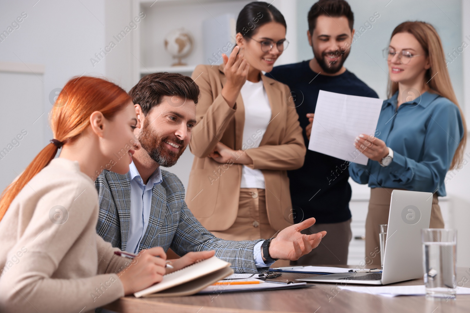 Photo of Team of employees working together in office