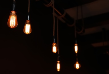 Photo of Glowing lamp bulbs in dark room. Interior element