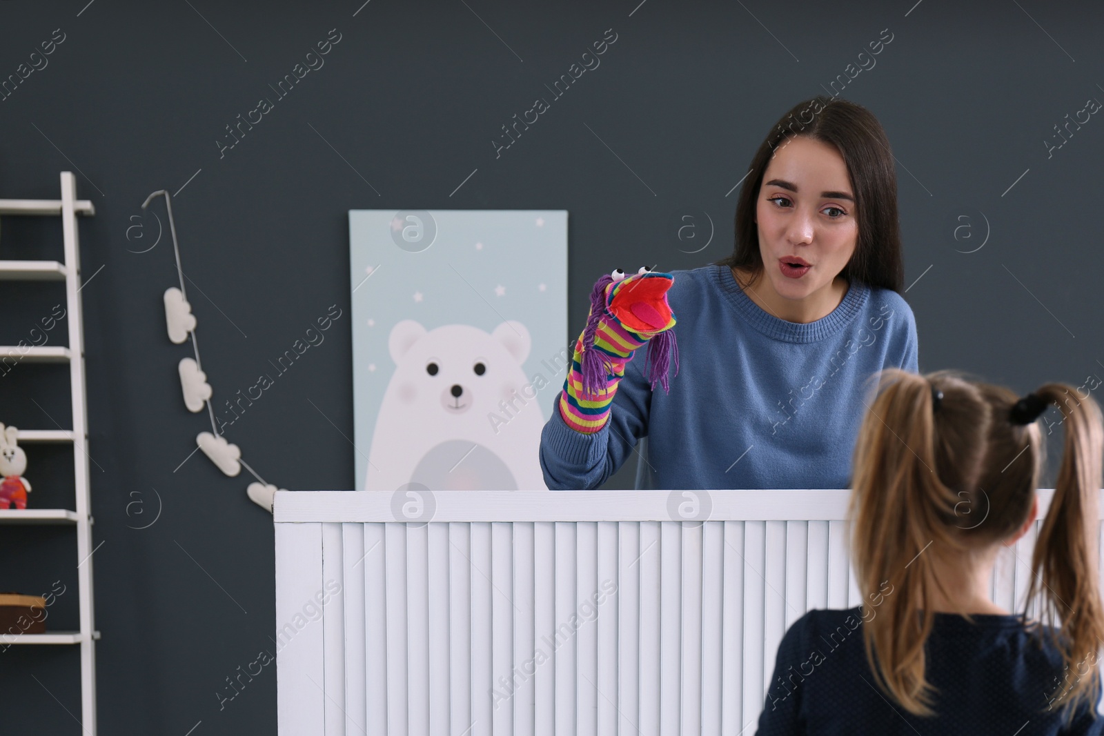 Photo of Mother performing puppet show for her daughter at home