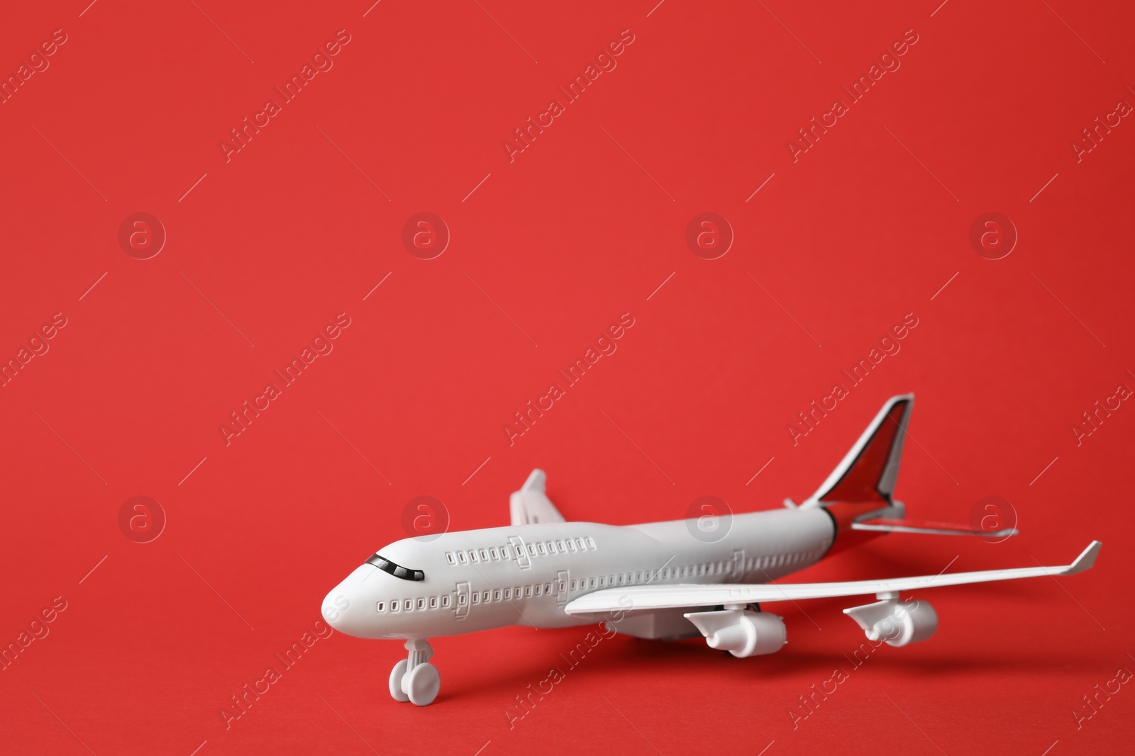 Photo of Toy plane on red background, space for text. Logistics and wholesale concept