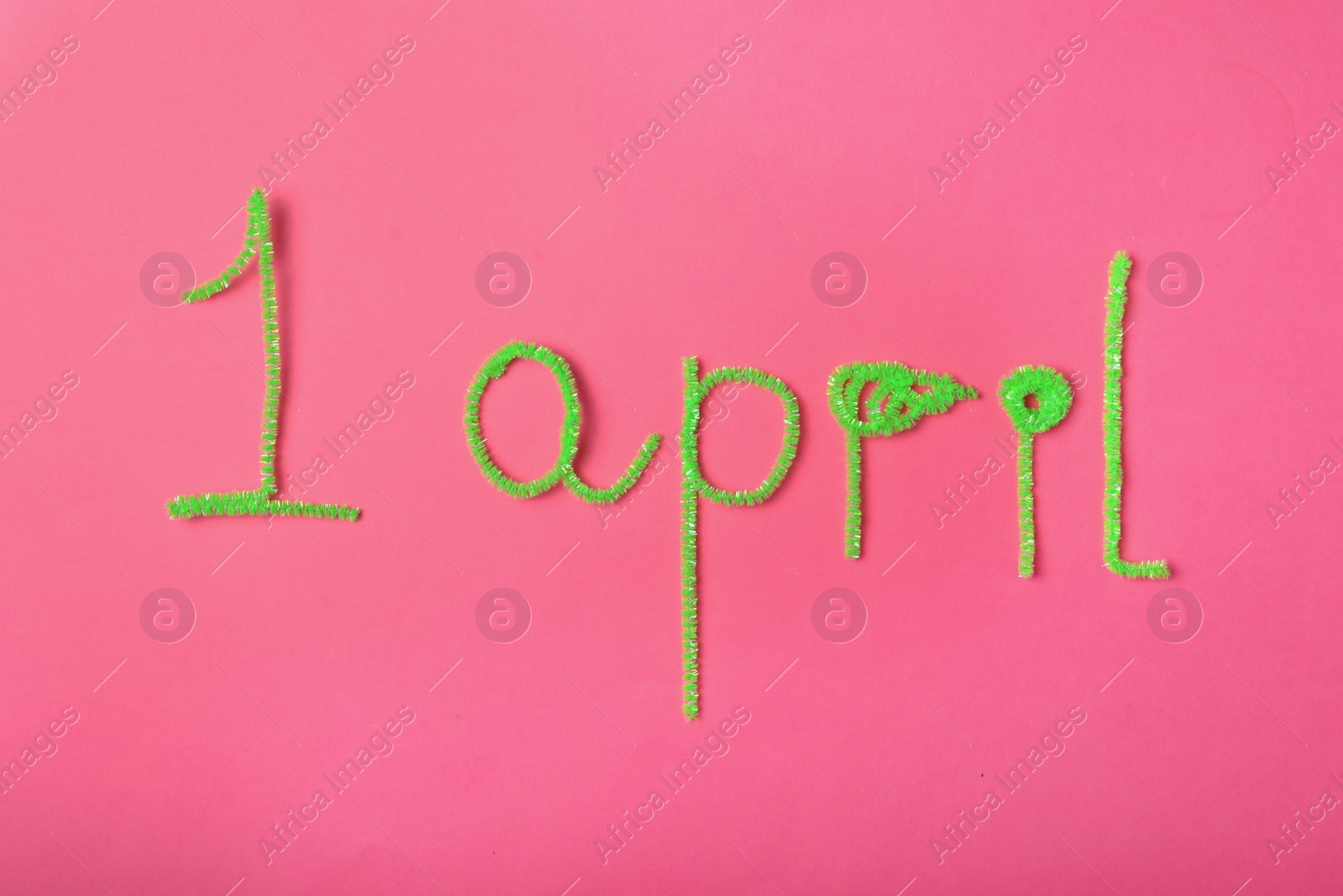 Photo of Phrase 1st APRIL on pink background, flat lay. Fool's Day