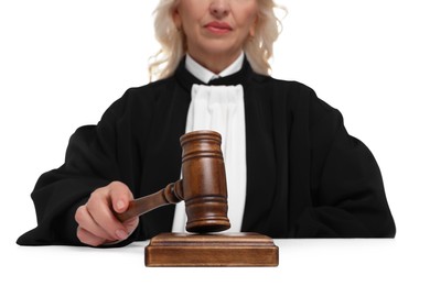 Photo of Judge with gavel at table on white background, closeup