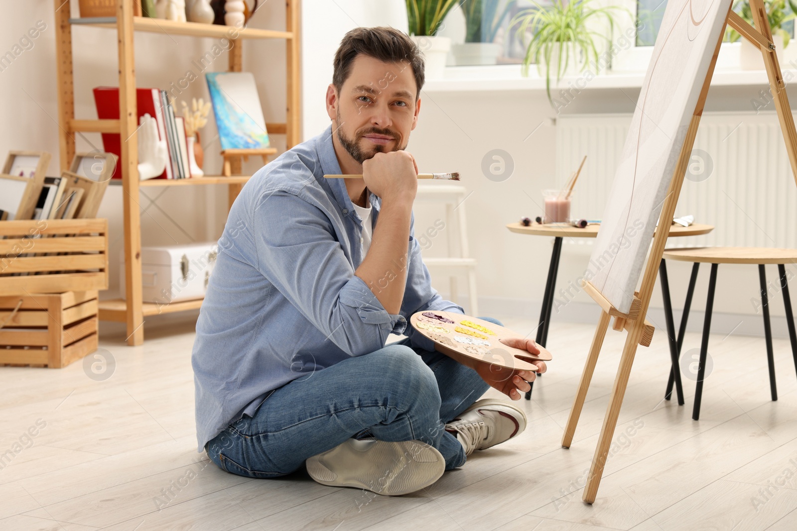 Photo of Handsome man painting in studio. Creative hobby