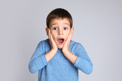 Photo of Portrait of emotional little boy on light grey background