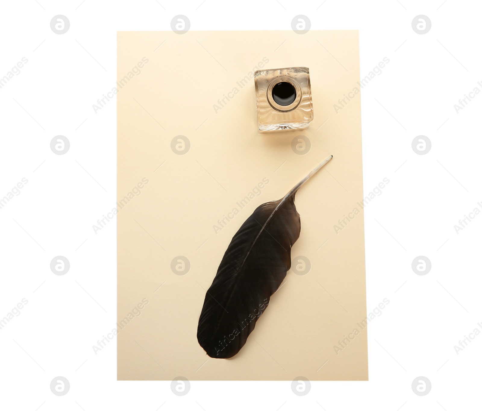 Photo of Feather pen, inkwell and sheet of paper on white background, top view. Space for text