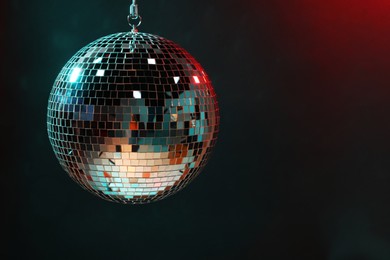 Photo of Shiny disco ball on dark background, space for text