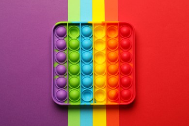 Photo of Rainbow pop it fidget toy on color background, top view