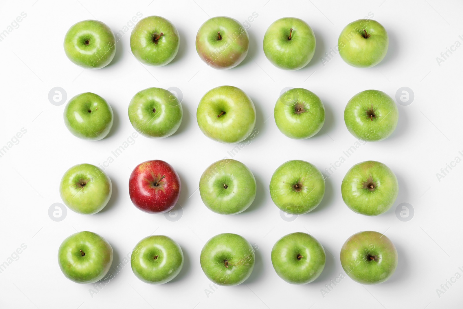 Photo of Red apple among green ones on white background, top view. Be different