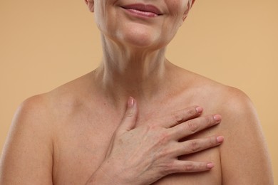 Photo of Mature woman with healthy skin on beige background, closeup
