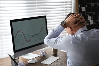 Photo of Businessman stressing out at workplace in office