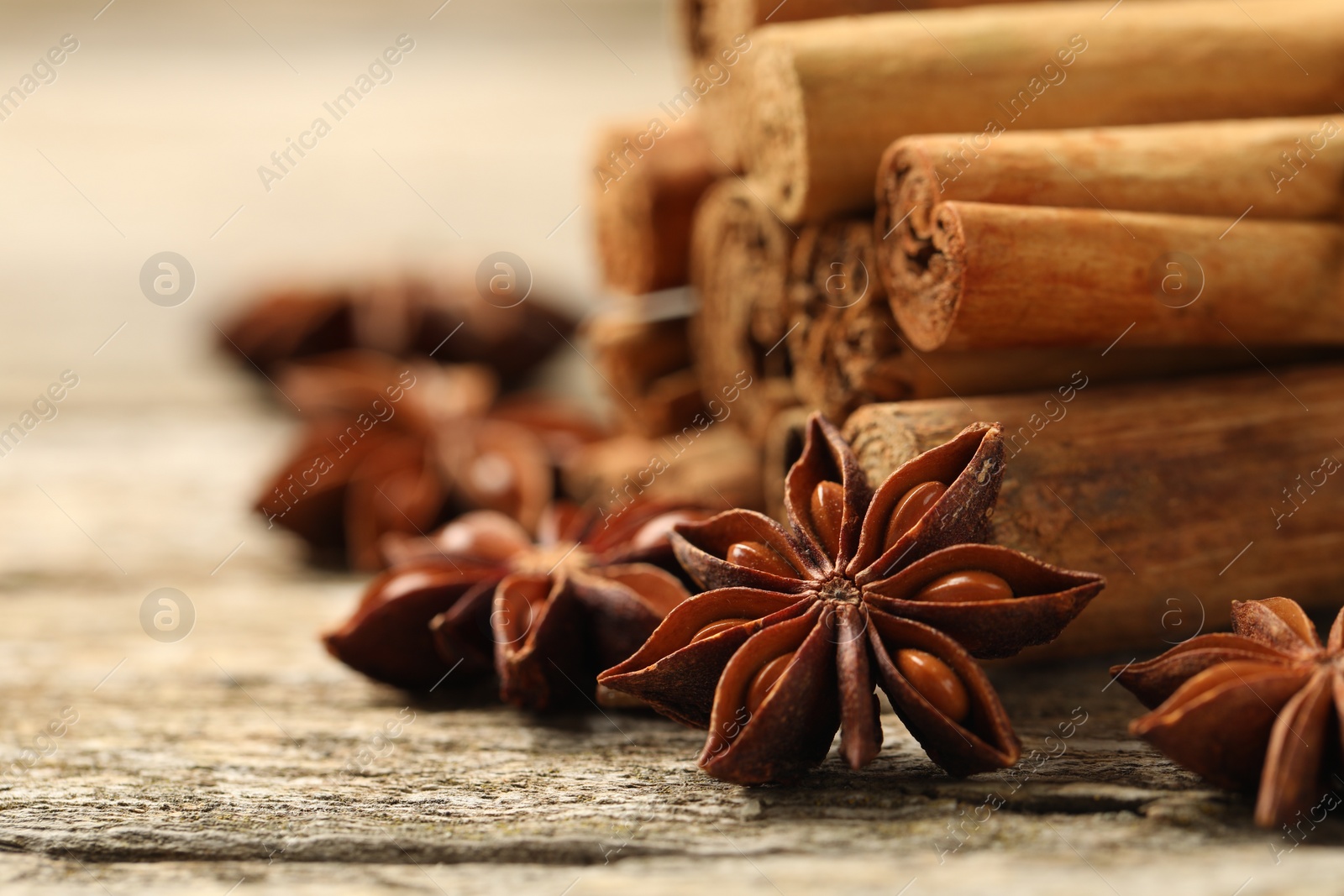 Photo of Cinnamon sticks and star anise on wooden table, closeup. Space for text