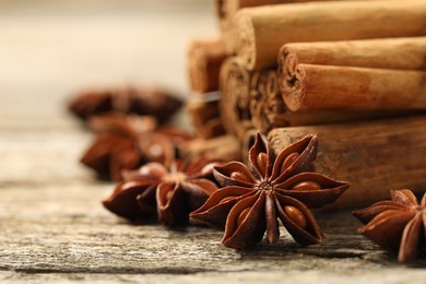 Photo of Cinnamon sticks and star anise on wooden table, closeup. Space for text