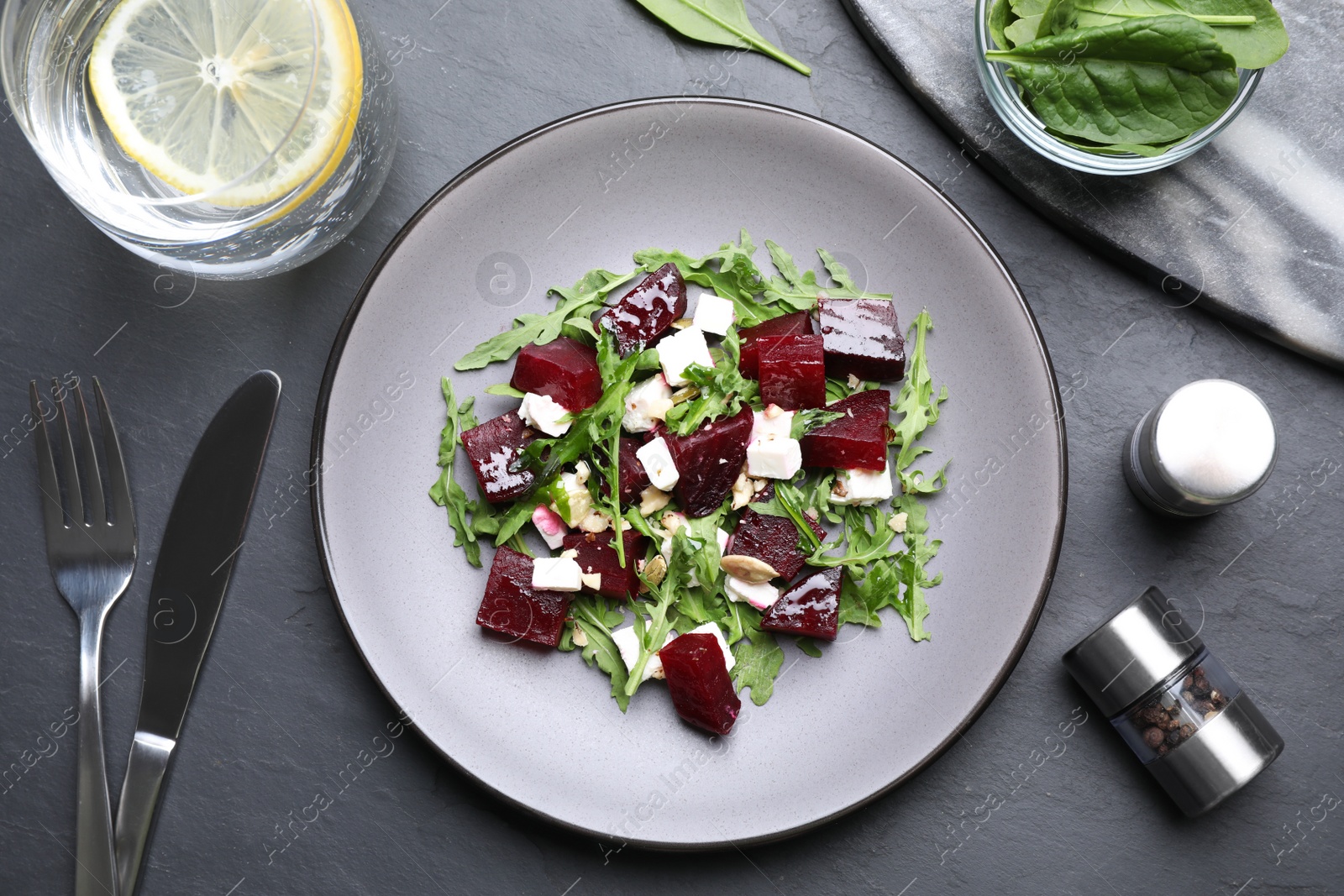 Photo of Delicious beet salad served on black table, flat lay