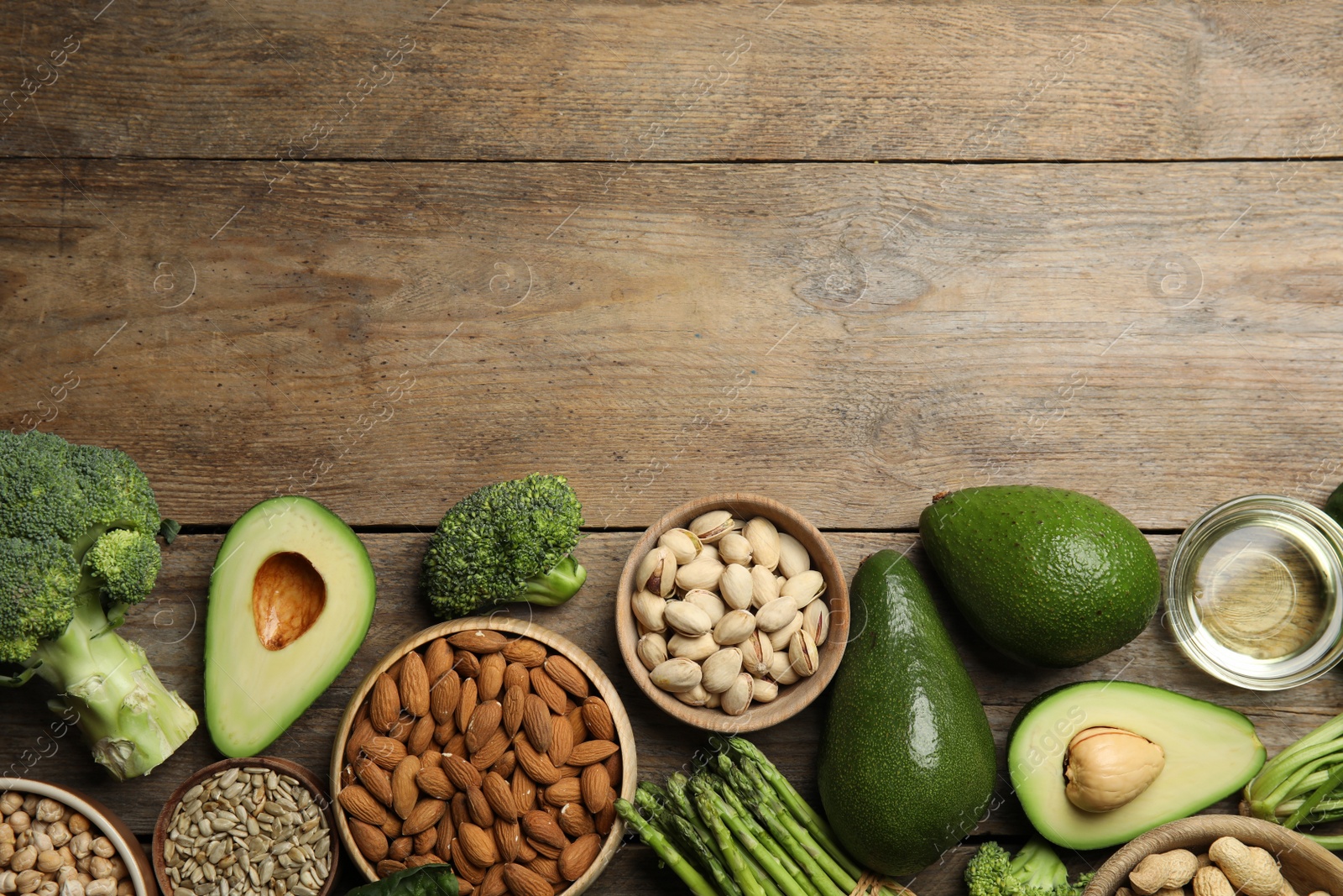 Photo of Different products rich in vitamin E on wooden table, flat lay. Space for text