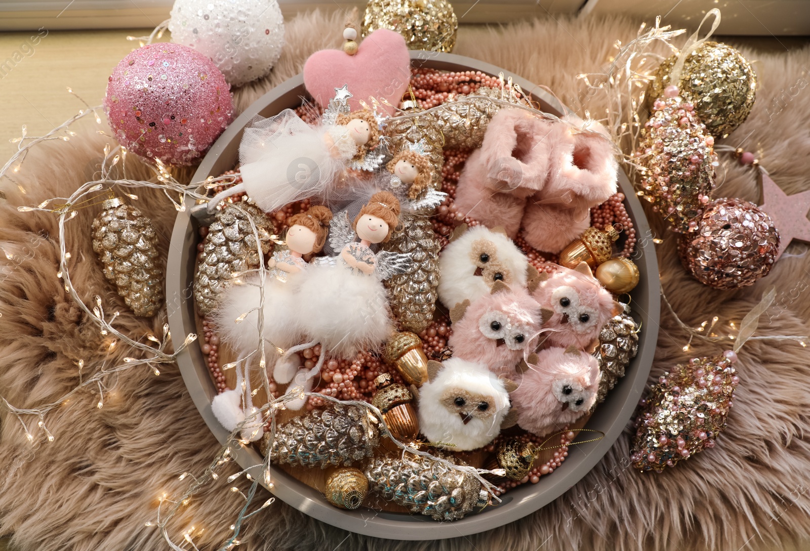 Photo of Beautiful Christmas tree baubles, toys and fairy lights on faux fur, flat lay