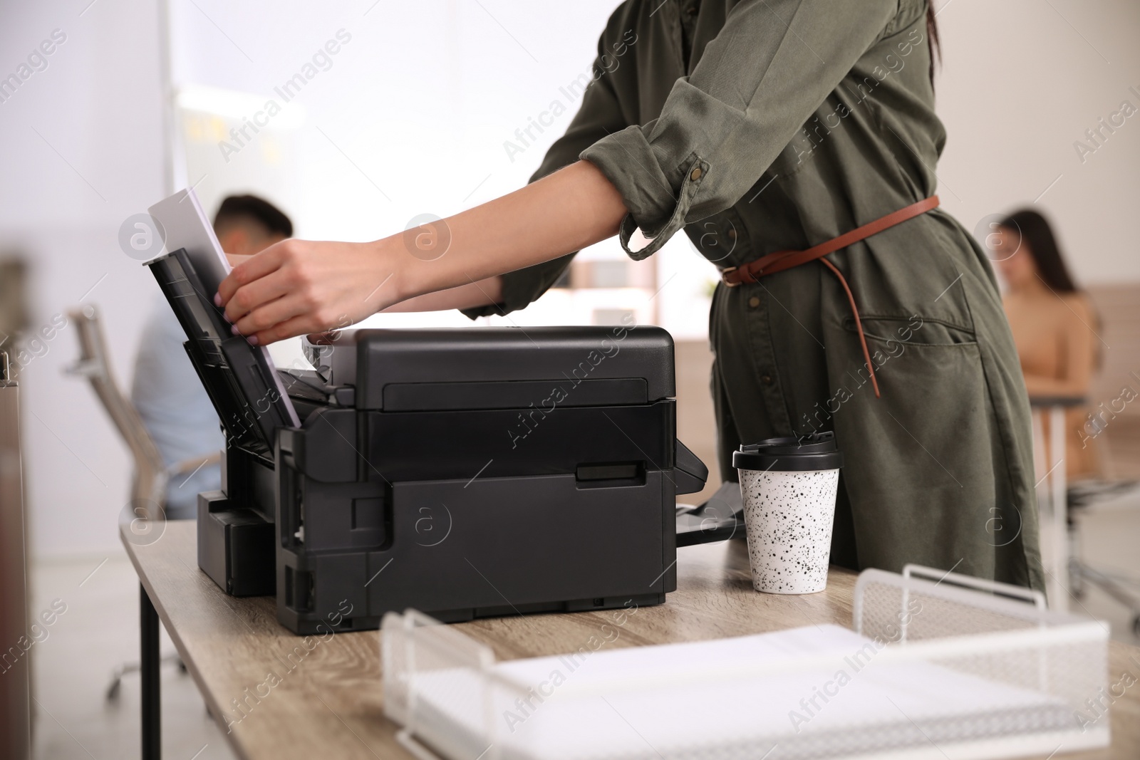 Photo of Employee using modern printer in office, closeup