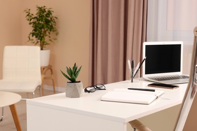 Photo of Cozy receptionist workspace with laptop on desk in office