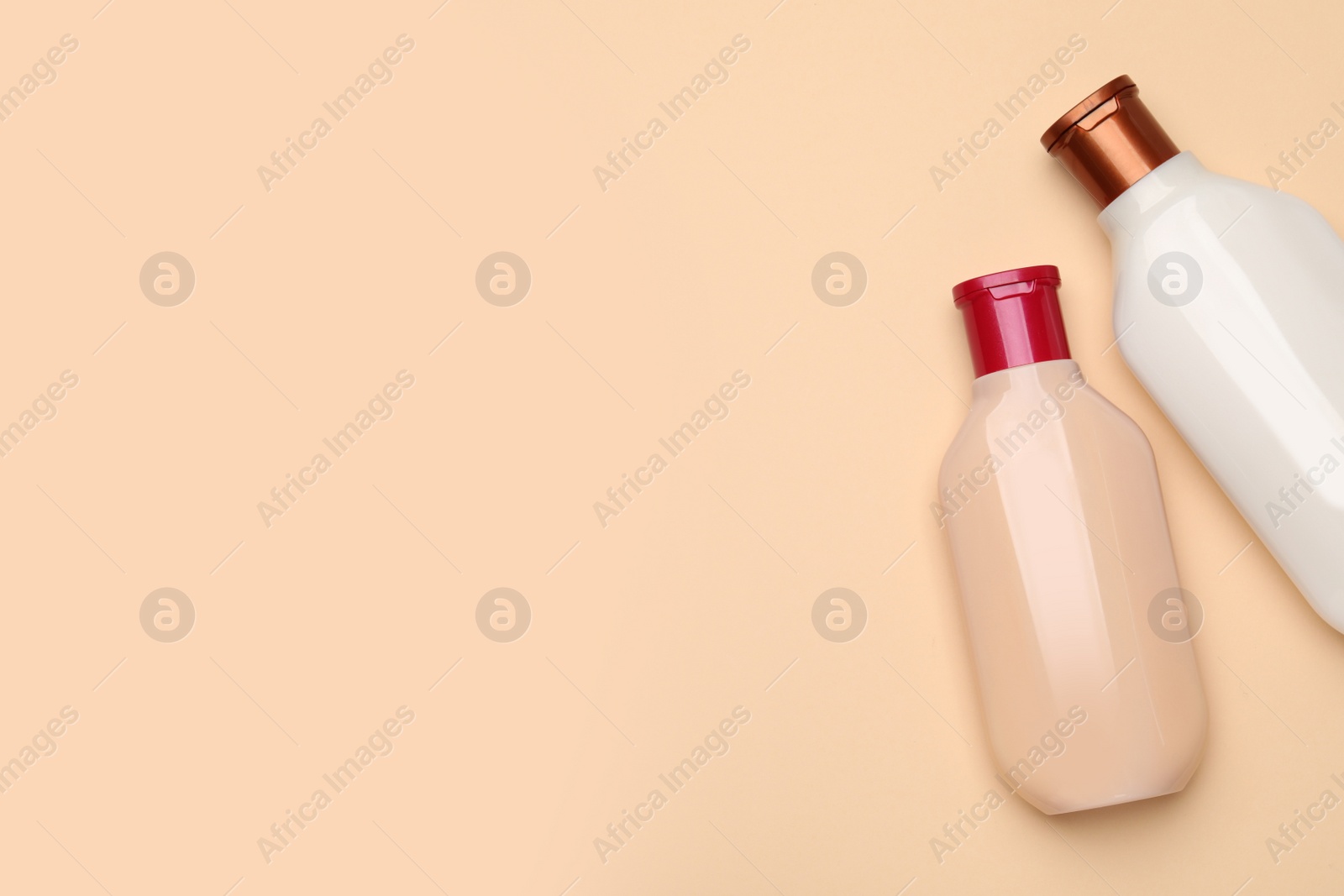Photo of Bottles of shampoo on beige background, flat lay. Space for text