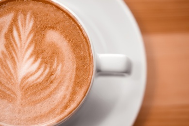 Photo of Cup of aromatic coffee on wooden background, closeup