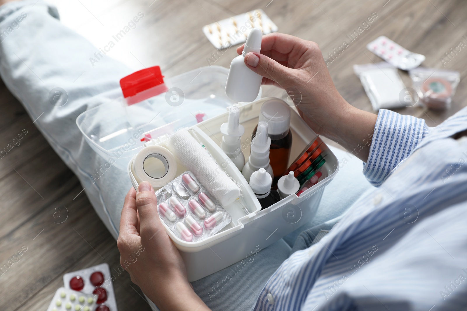 Photo of Woman putting medicament into first aid kit indoors, above view