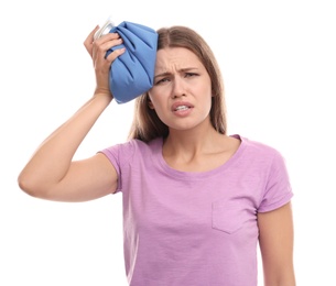 Unhappy woman using cold pack to cure headache on white background