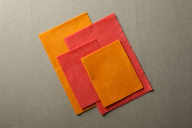 Photo of Colorful reusable beeswax food wraps on grey background, top view