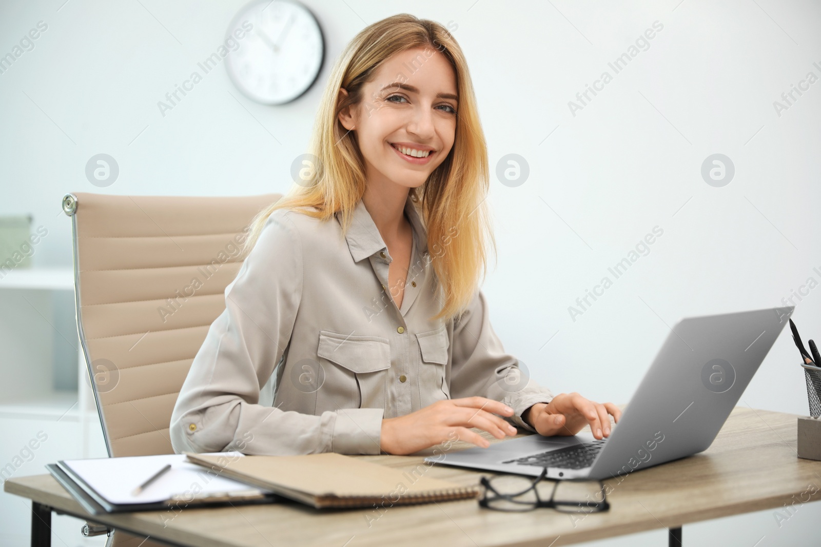 Photo of Pretty young woman working with laptop in office