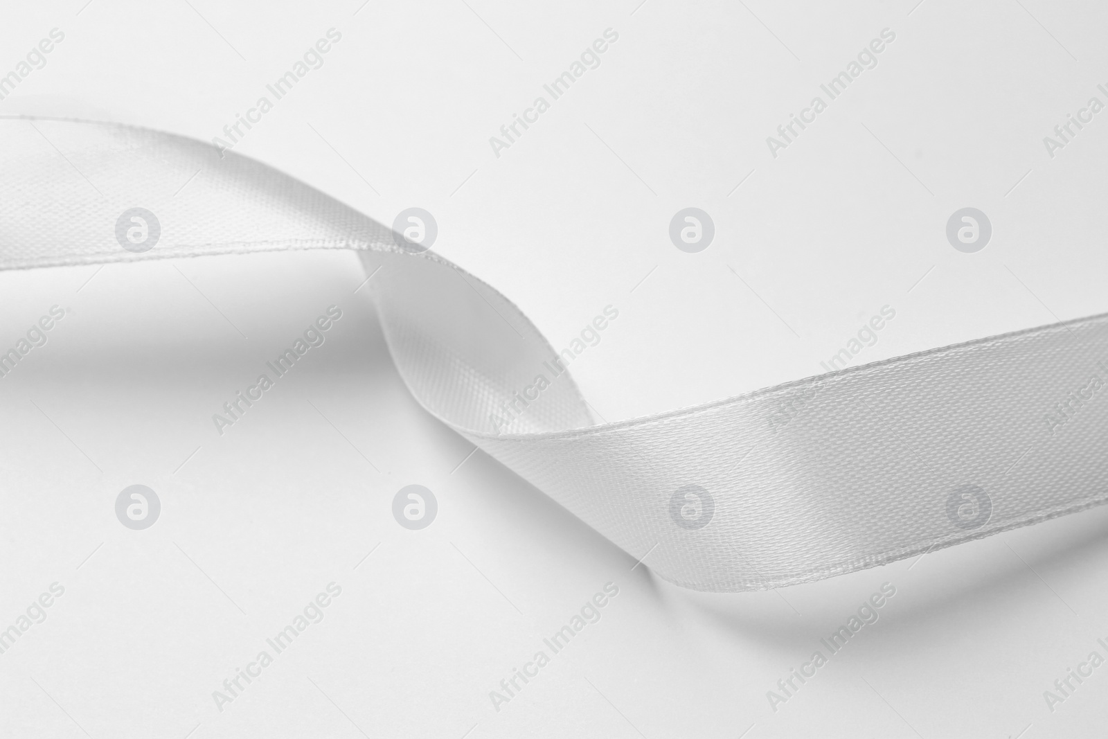 Photo of One beautiful silk ribbon on white background