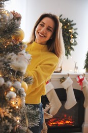 Photo of Beautiful woman decorating Christmas tree at home