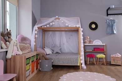 Photo of Stylish child room interior with comfortable house bed