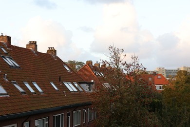 Beautiful buildings and trees in city under sky with clouds