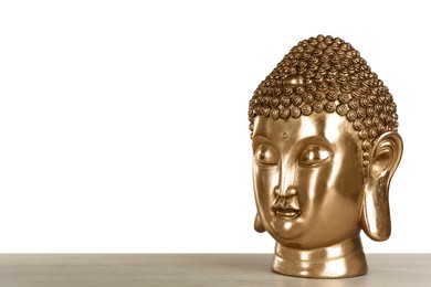 Beautiful golden Buddha sculpture on wooden table against grey background. Space for text